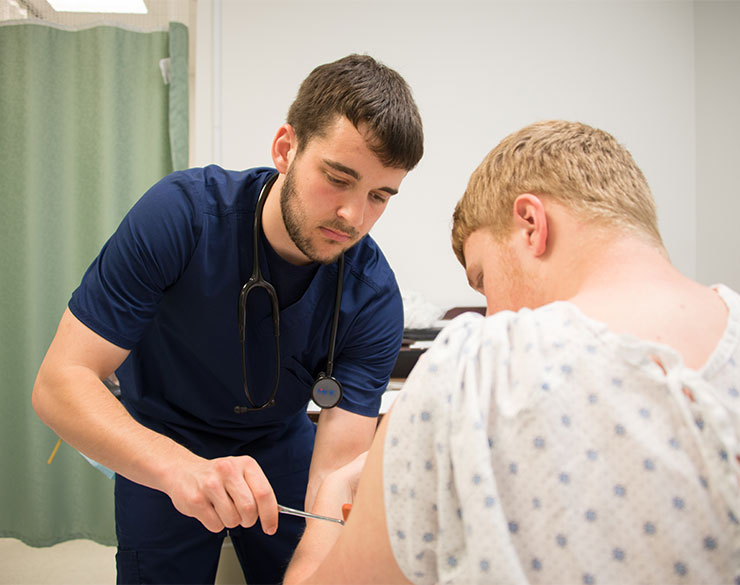 Nursing student examines patient