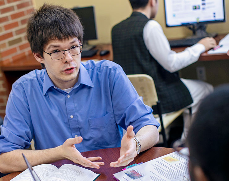 Male student speaking to another student