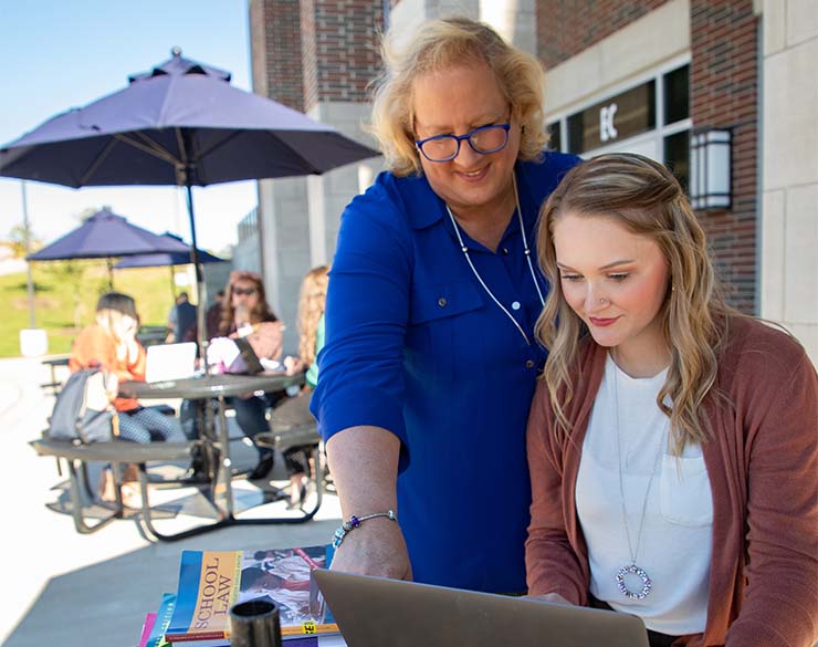 A faculty member helps a student