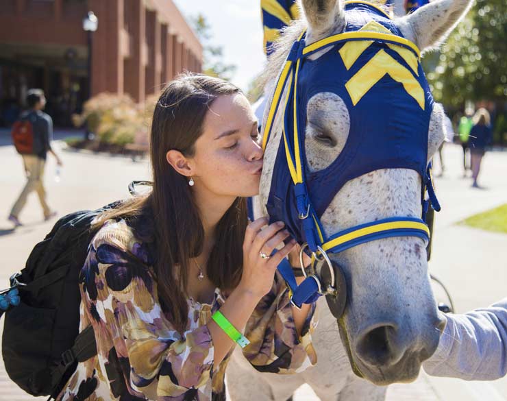 Student kisses the Murray State mascot Racer One