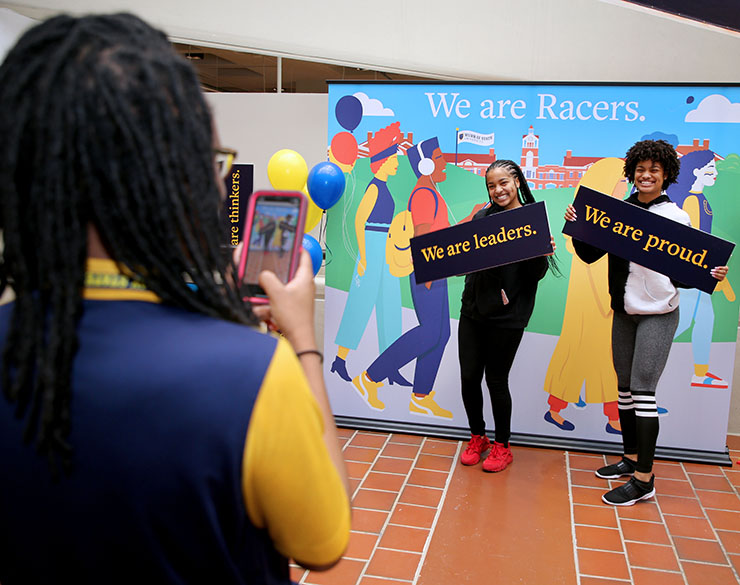 Two students pose with signs