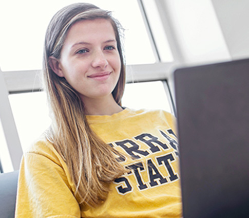 A girl works on her laptop at a regional campus