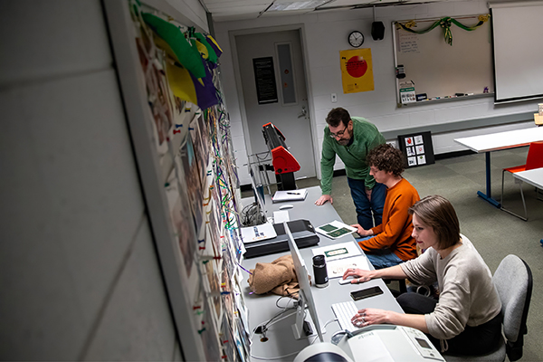 Professor Jim Bryant assists students working on their design projects.