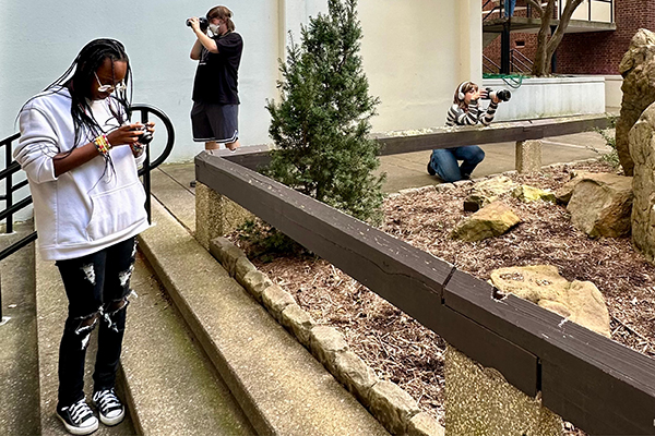 Photography students take photos outside in the zen garden.