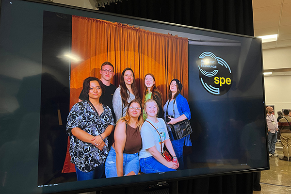 Professor Cintia Segovia Figueroa and a group of photography students take a photo at the Society for Photographic Exchange conference in 2026.