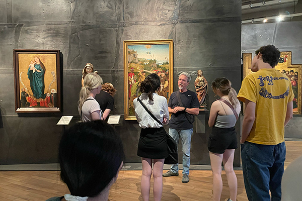Dr. “ZB” Smetana and a group of art history students tour a museum with Renaissance artworks on display. 