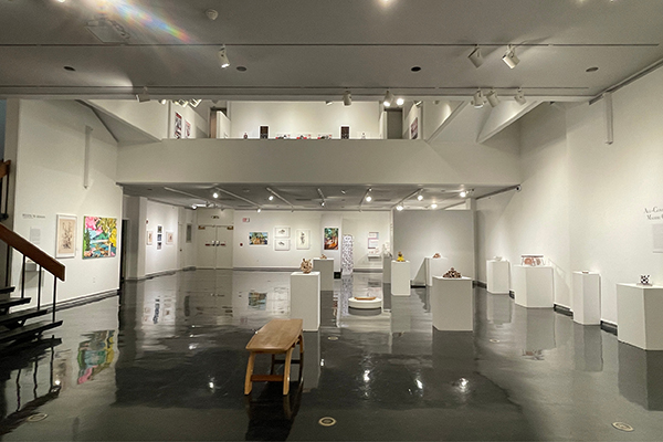 The Clara M. Eagle Gallery is a large, spacious room with artworks along the walls and on portable stands; the Eagle Upper Gallery is visible from the lower level.