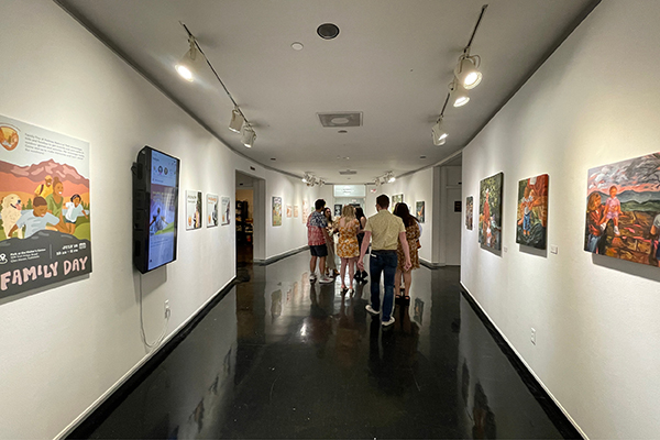 Students look at the art on display as they pass through the Mary Ed Mecoy Hall Gallery.