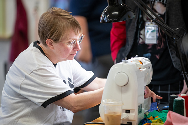 Professor Sarah Martin demonstrates how to use a sewing machine. 
