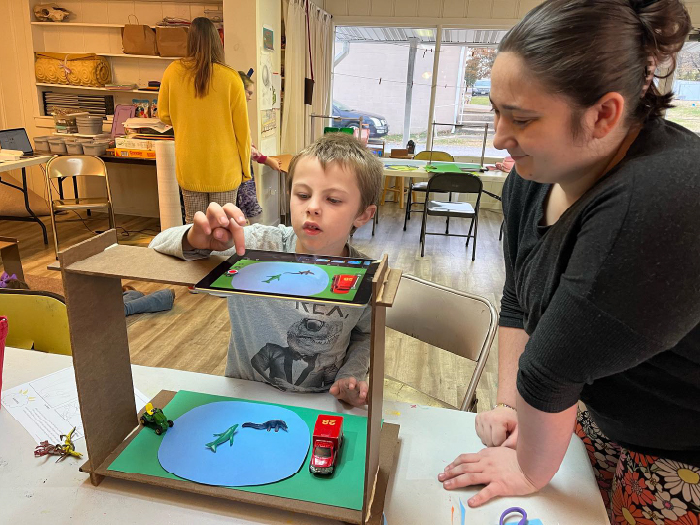 An art education student assists an elementary school student with his stop-motion animation project.
