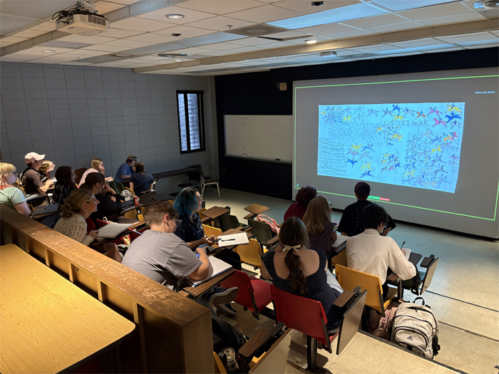 Art history students learn about an artwork depicting the Battle of the Little Bighorn. 