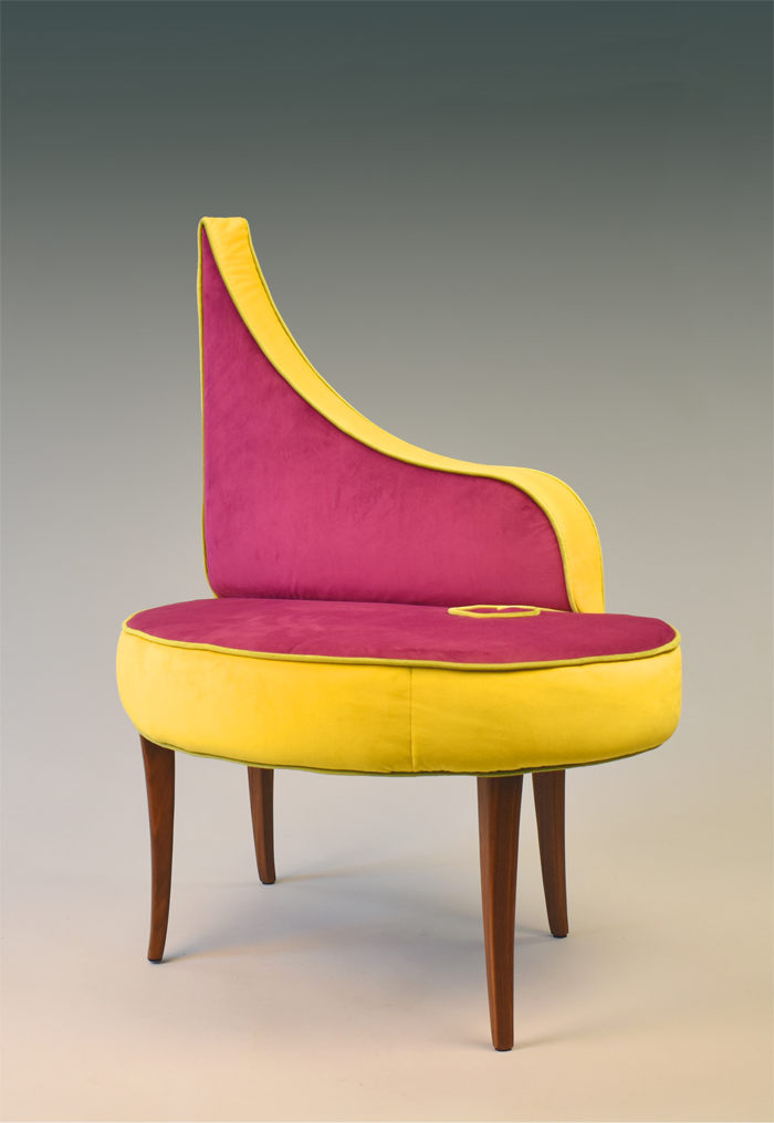 A handcrafted wooden chair with a pink-and-yellow cushion and back made by student Beth Donovan. 