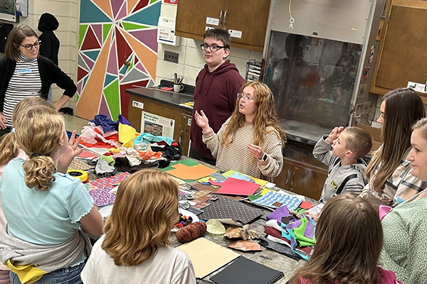 Art Education students encourage middle school art students to create mixed-media collages. 