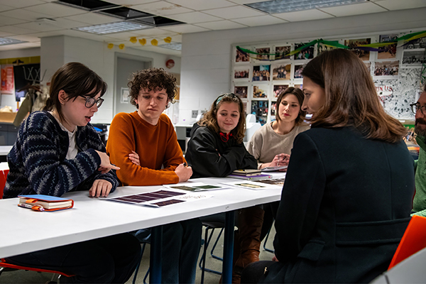 Professor Jim Bryant reviews Taste of the Arts invitations made by graphic design students. 