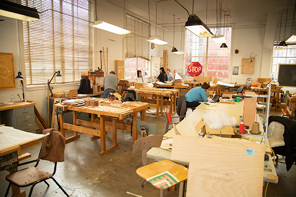 Overview of the woodworking studio. There are multiple workstations with the tools necessary for woodworking.