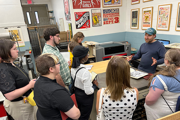 Art & Design students learn from a poster designer at his studio. 