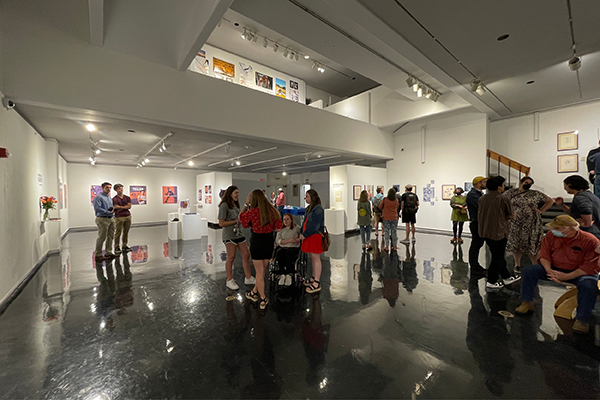 A crowd of students, professors, and community members gathers for an exhibition reception in the Clara M. Eagle Gallery.