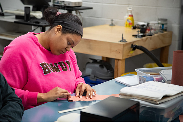 A bookbinding student focuses on her current project.