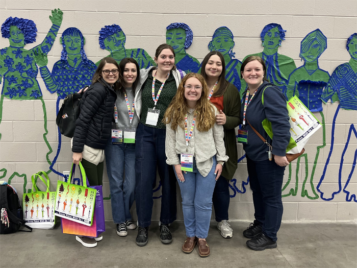 Dr. Rebecca Williams smiles with art education students at the NAEA conference.