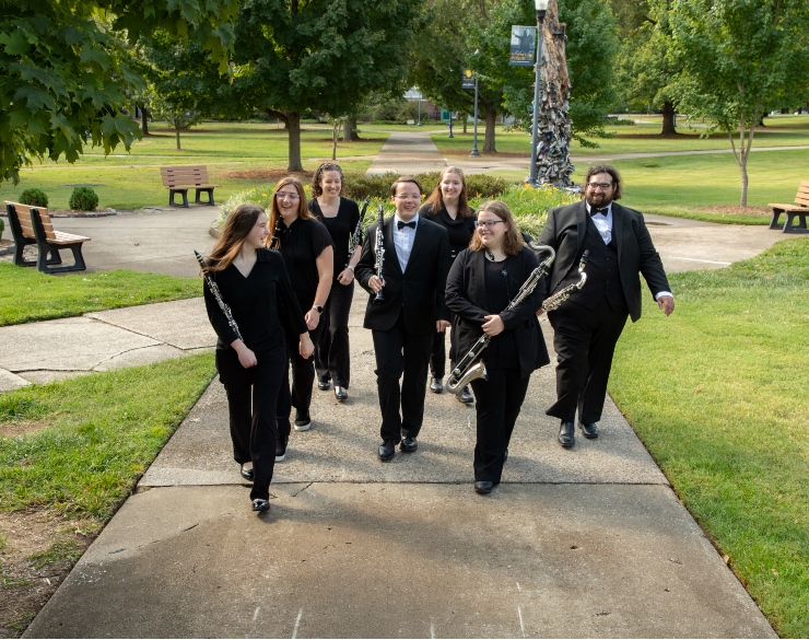 Musicians walking across the quad.