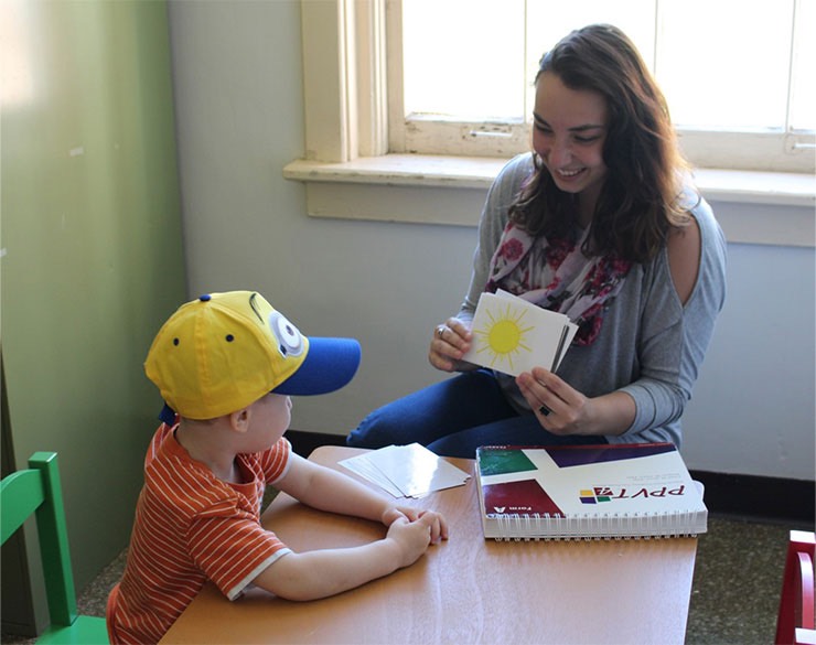 Student showing picture cards to child