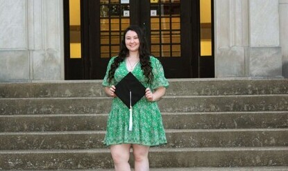 Hannah Reynolds poses on the steps with her graduation cap.