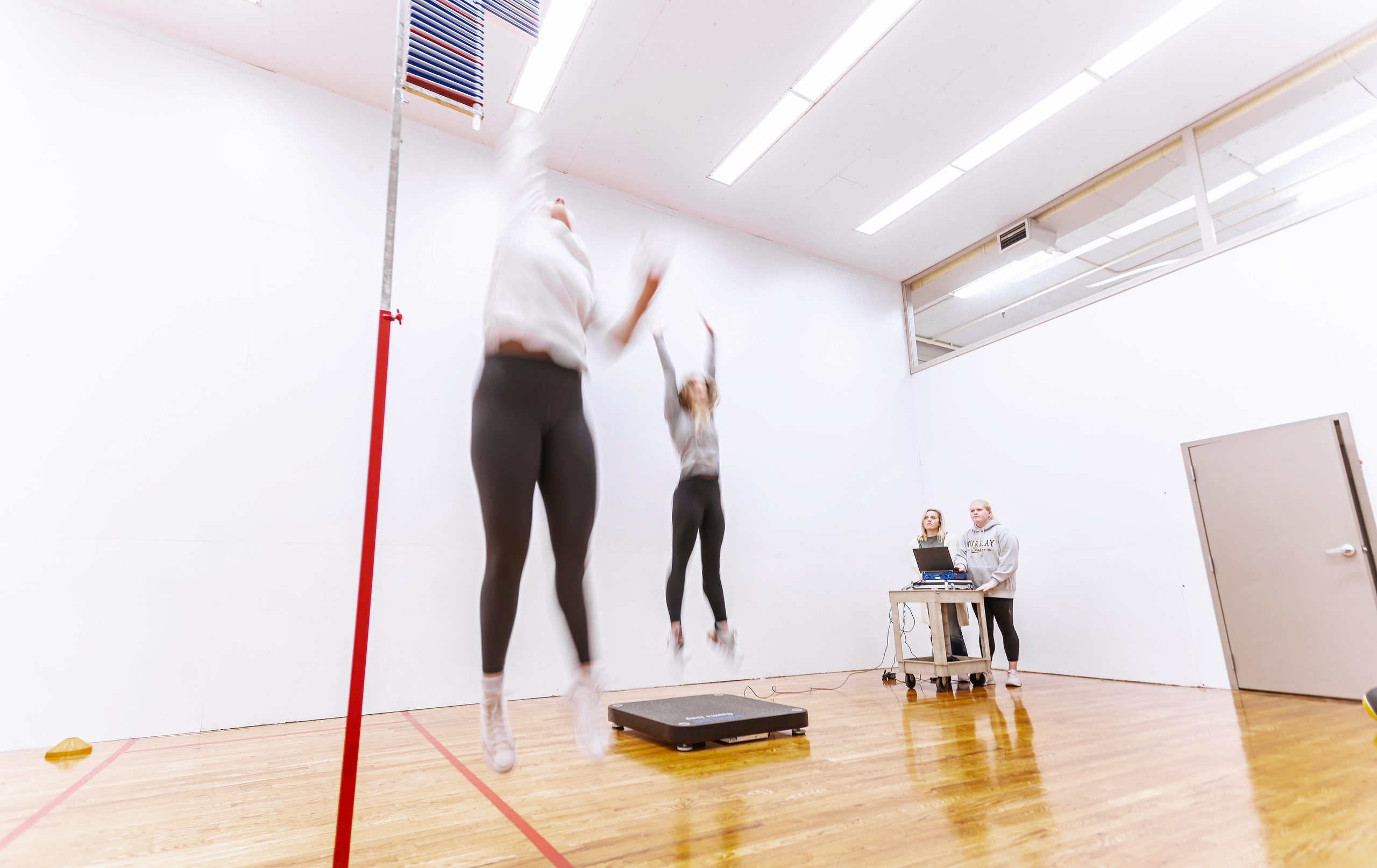 Students jumping in the air and looking at computer