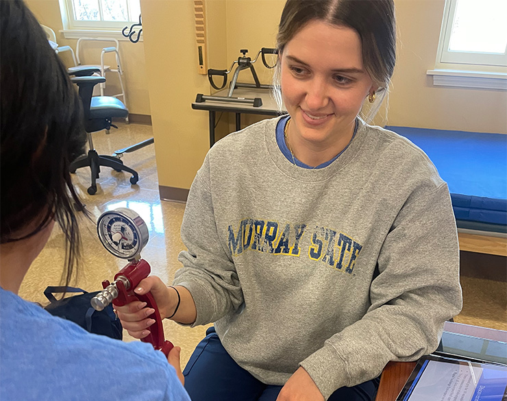An OT student examines a mock patient
