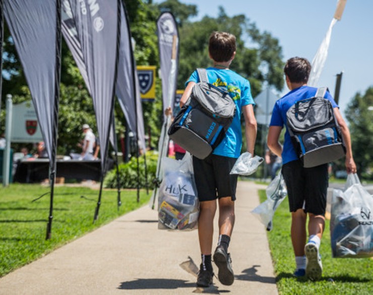 Two campers holding bags walking towards a Murray State residence hall