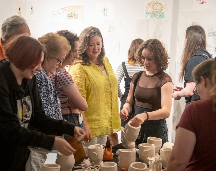 SAW campers and families admiring ceramic pieces