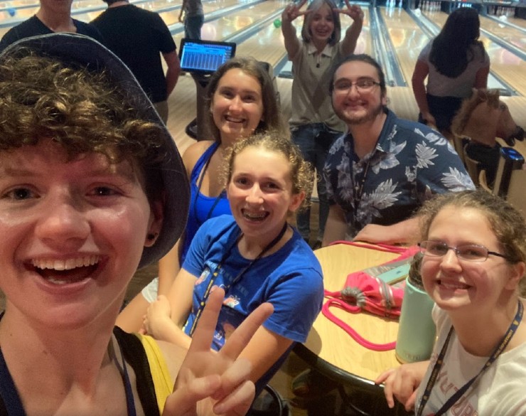 Five campers and one camp counselor similing at the bowling alley