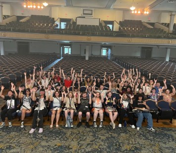 Class of 2023 RIMA campers sit in Lovett Auditorium, making the Murray State "Shoes Up!" symbol with their hands to look like horseshoes