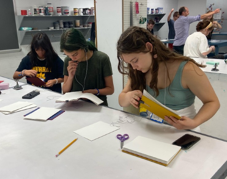 Campers bookbinding in a studio classroom