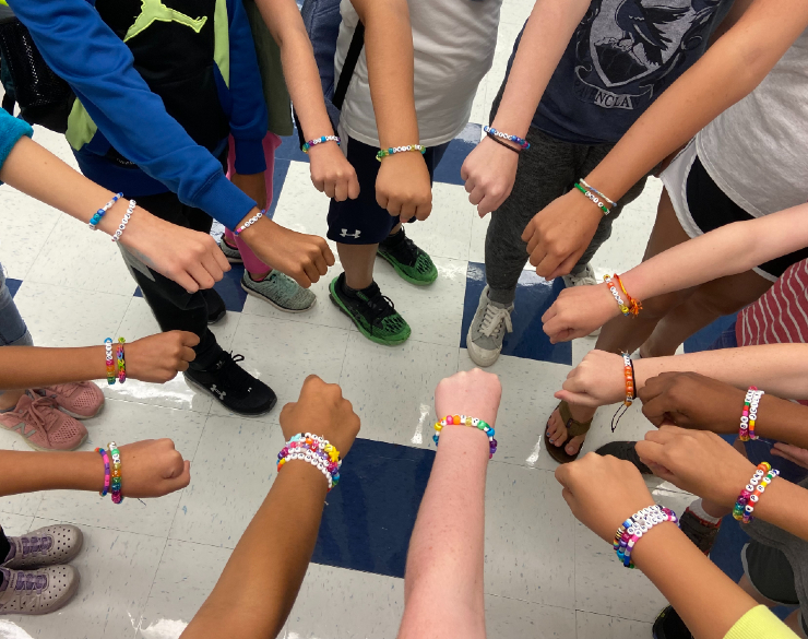 Campers displaying bracelets they made