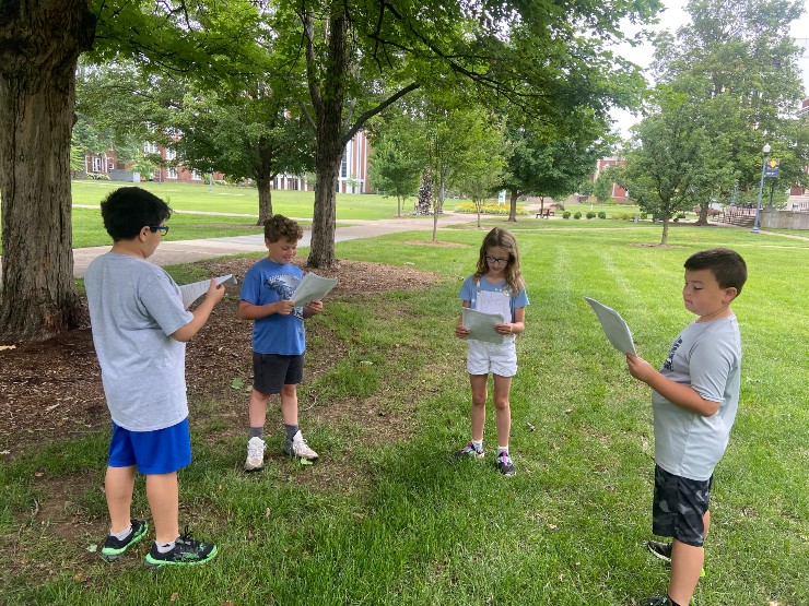 Campers reading their writings to each other in MSU's quad