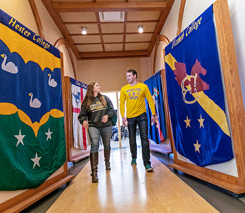 Two students walk by residential college banners