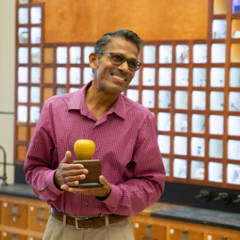 professor holds golden apple