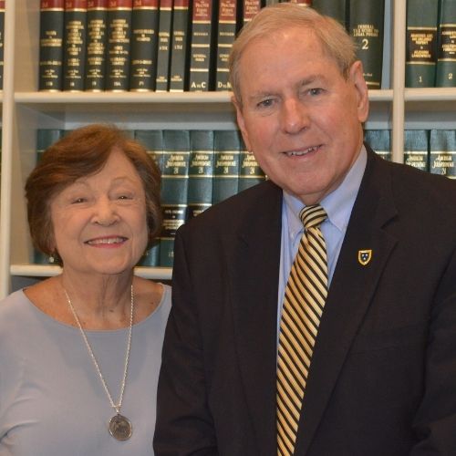 Jerry and Judy Rhoads in front of bookcase.