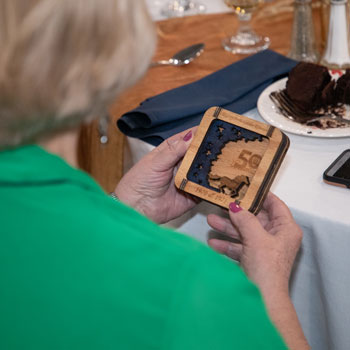 Woman holds momento at 2021 Golden Reunion