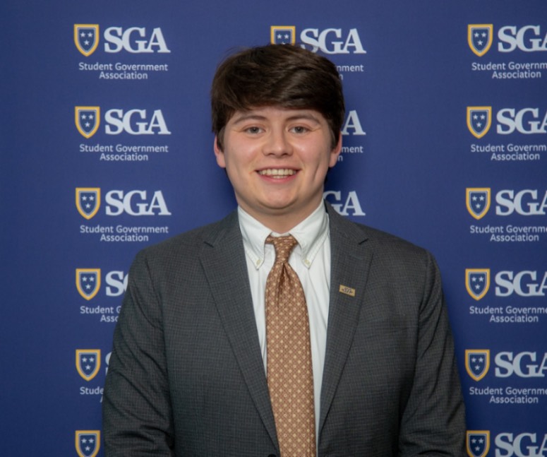 Cesar Villeda in a suit, brown tie, and white shirt.