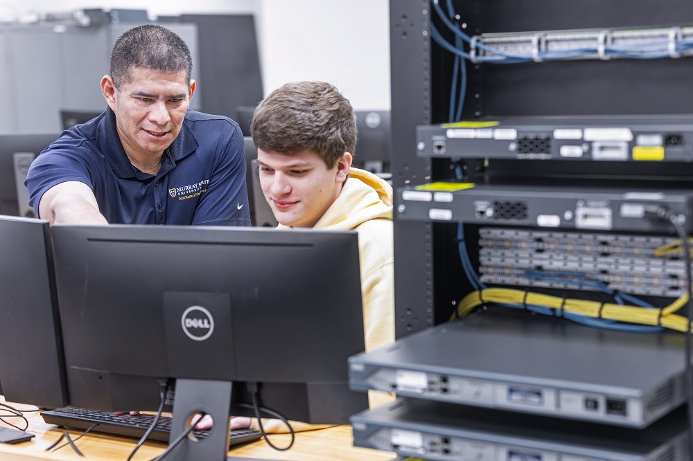 A faculty member assists a student.