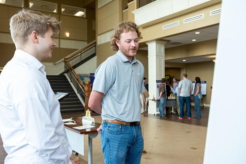 An image of a student speaking with an engineer during an expo focused on the Paducah Student Summary of the Annual Site Environmental Report.