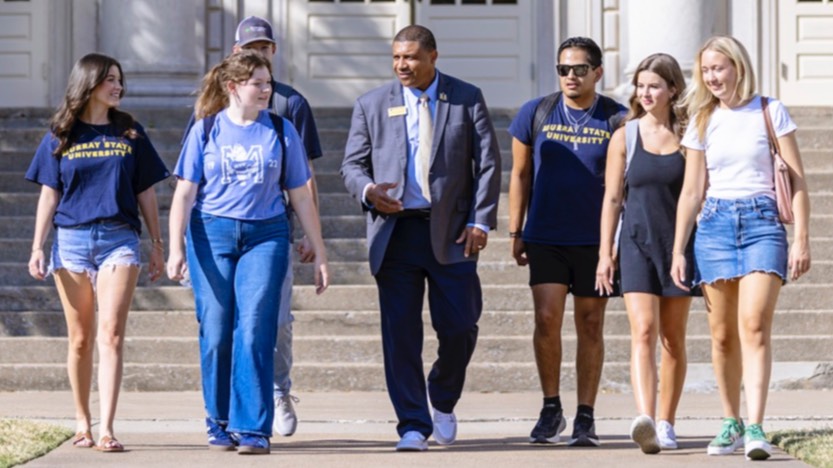 Dr. Ron K. Patterson walks and talks with six college students.