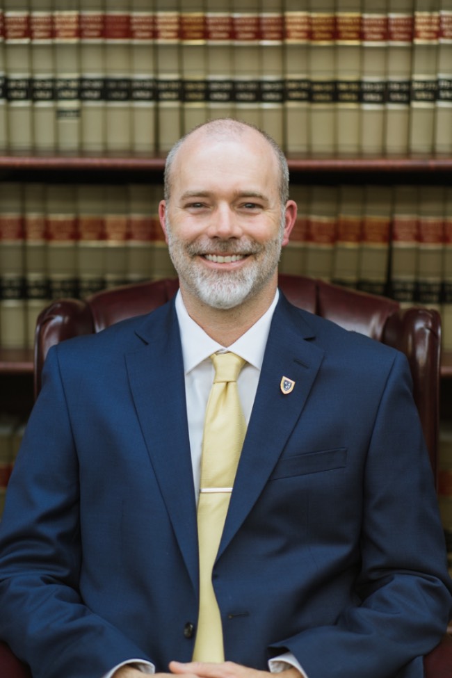 Dr. Robbie Fitch in a blue suit, yellow tie and white shirt.