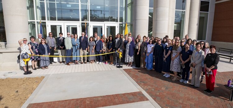 group of people behind yellow ribbon