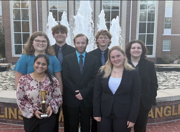 group of students standing in front of fountain