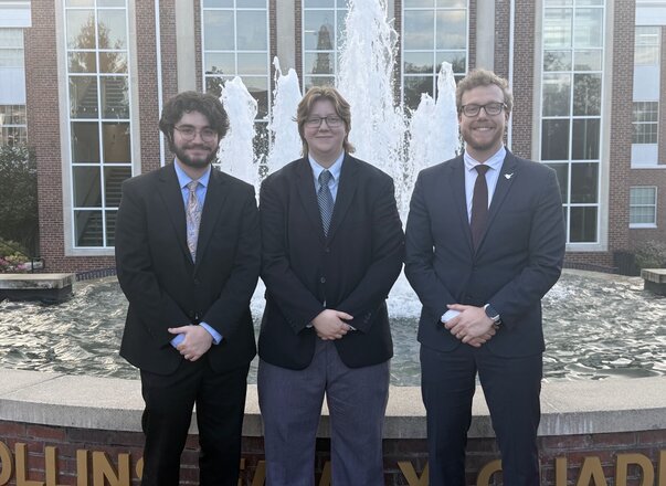 three men standing in front of fountain