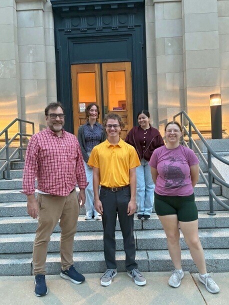 Students and faculty standing in front of building