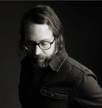black and white photo of Wes Blake wearing glasses